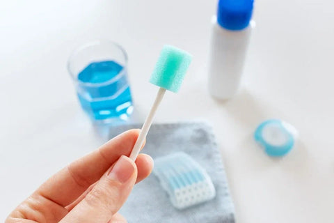 A hand holding a soft sponge toothbrush