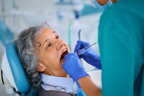 lderly woman having her teeth examined by a dentist during a routine dental check-up
